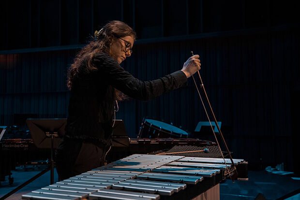 Female percussionist playing vibraphone with bow.