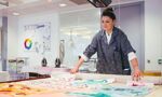 A student looking at pieces of textile design work on a table