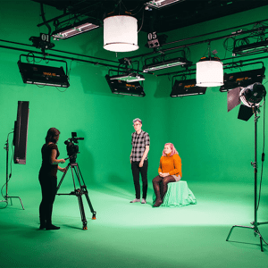 Students using camera in Studio B with green screen