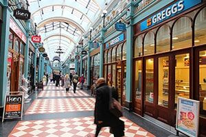 A shopper walks through an old Victorian shopping arcade