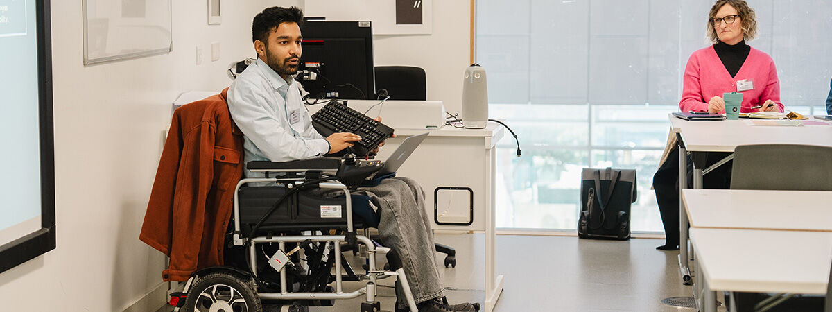 A presenter in a wheelchair speaks to a classroom