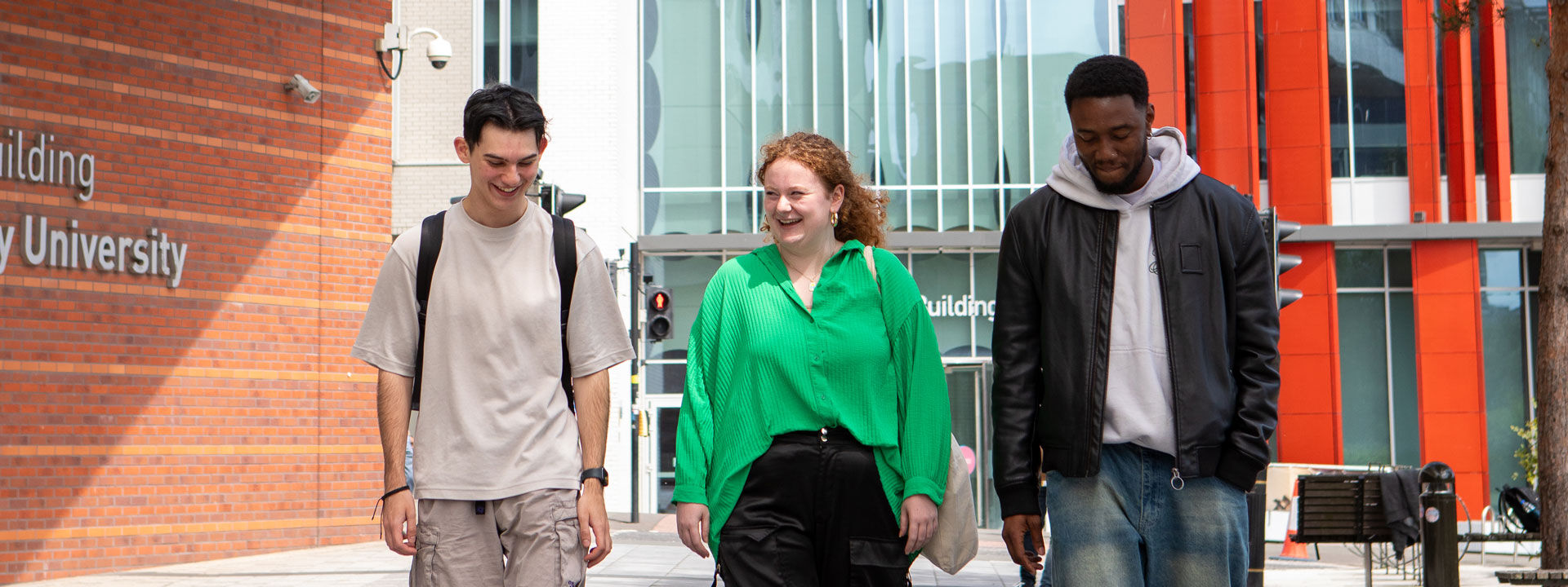 Three students walk through campus and talk