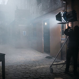 Filming on location on a misty cobblestoned street
