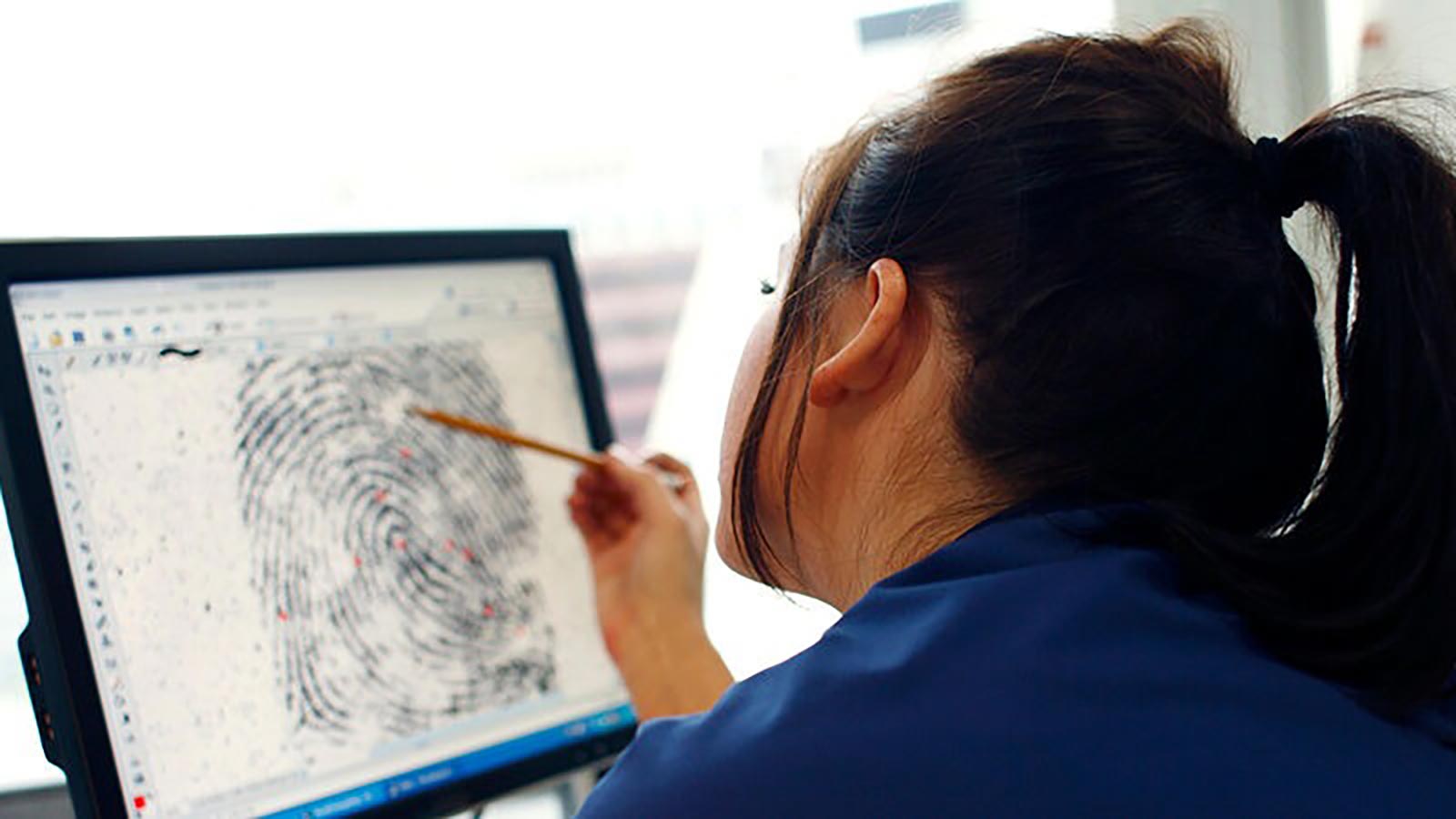 Student analysing fingerprint on computer monitor