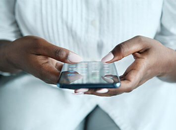 A black lady using her mobile phone to access apps