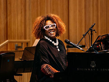 Errollyn Wallen playing piano and smiling