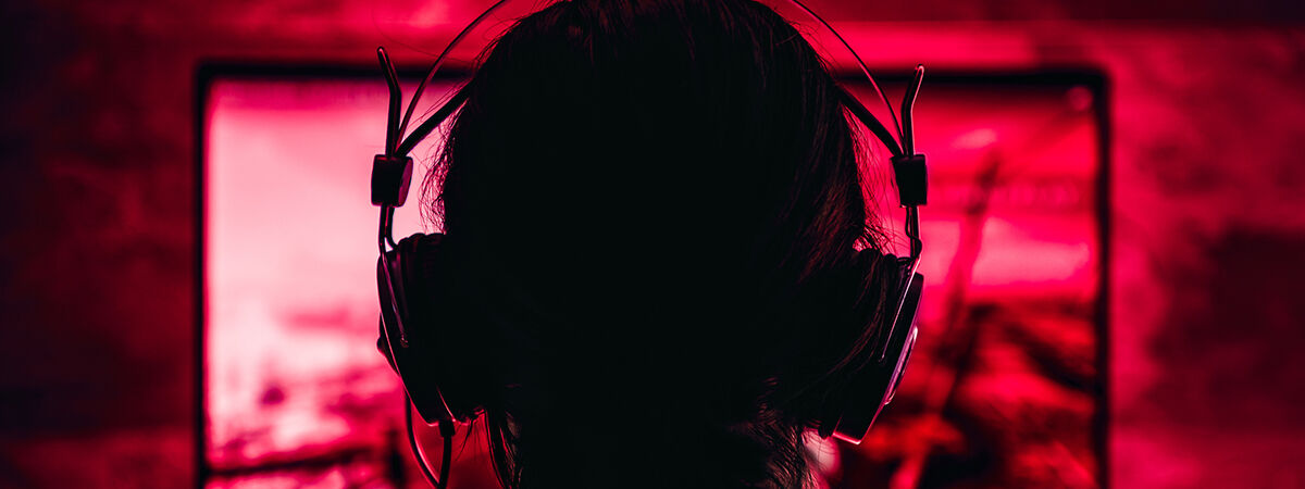 A person wearing headphones while playing video games