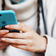 Close-up of hands using mobile phone in blue case