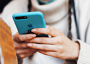 Close-up of hands using mobile phone in blue case