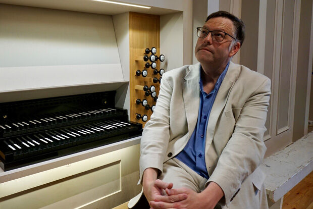 Organist Henry Fairs sat at the organ looking pensive