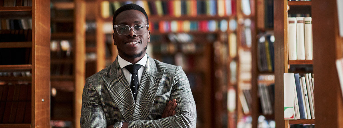 A black lawyer standing confidently in a library