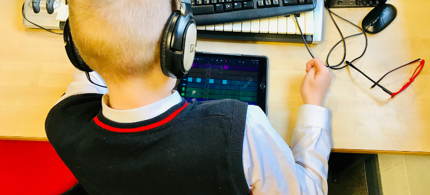Student with headphone using an ipad to create music