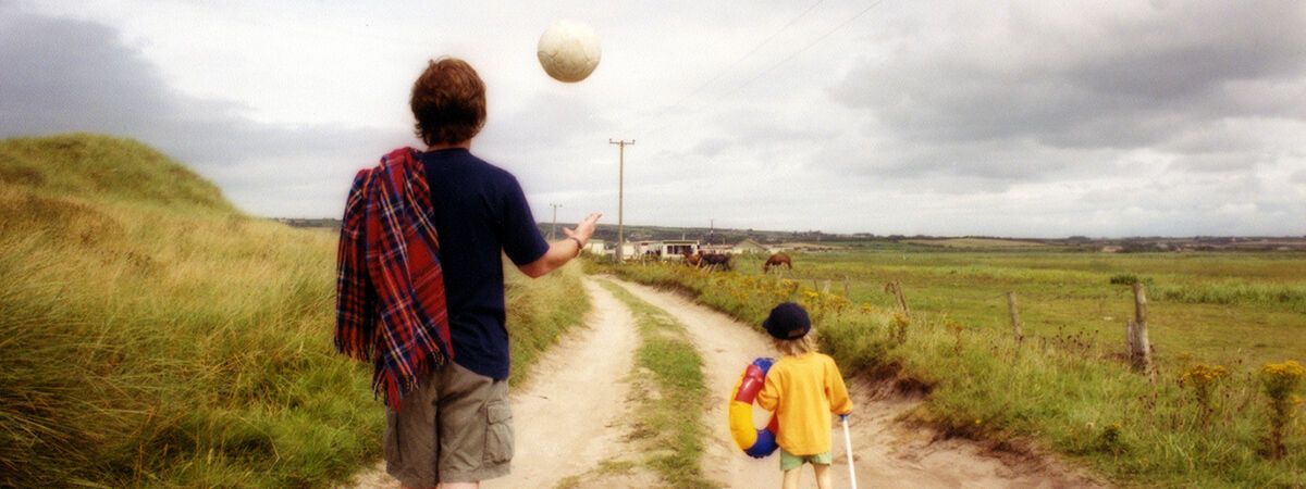 Photograph of man walking with son on a trail