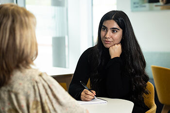 Two people sitting in the law clinic having a discussion 