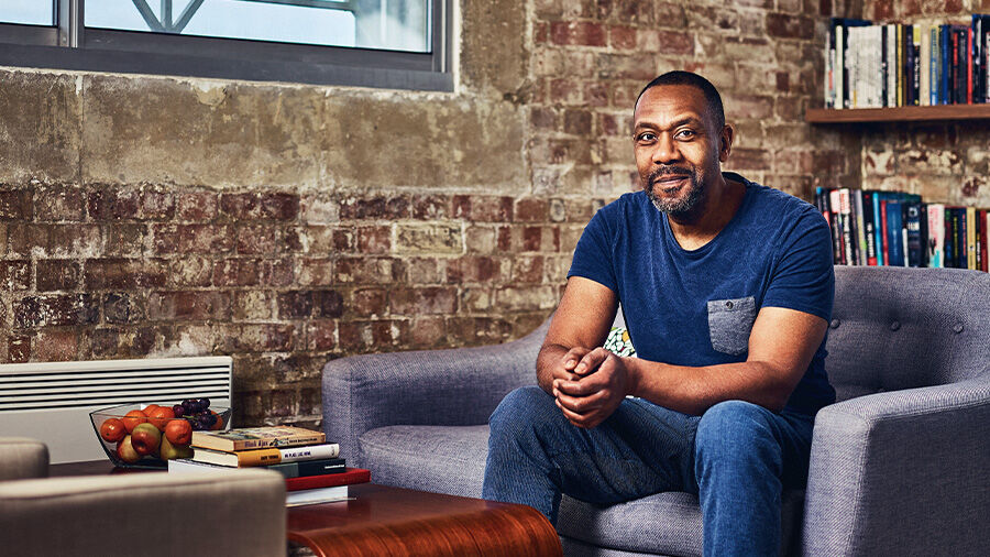 Lenny Henry sitting with books