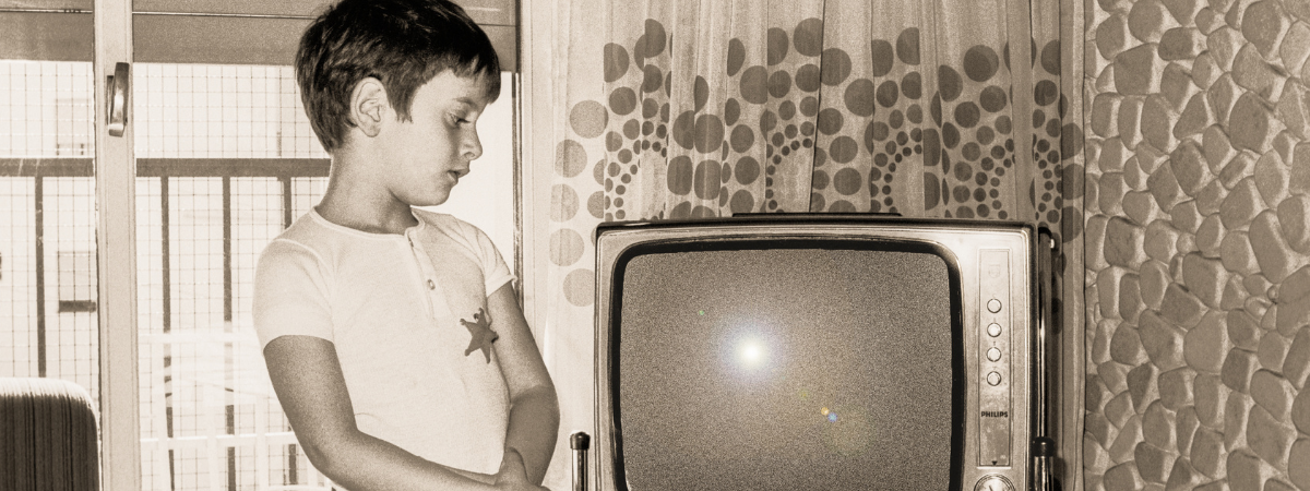 Young boy in the 60s looking at a TV