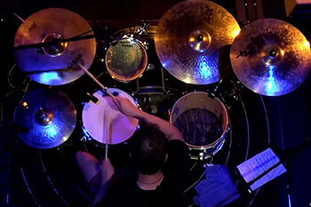 Image of a drummer playing their drum kit