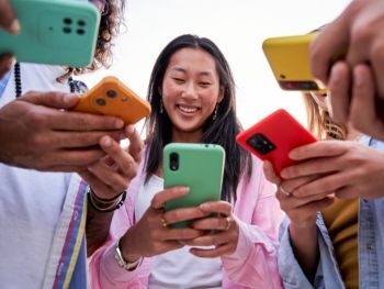 Group of women stood holding mobile phones