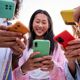 Group of women stood holding mobile phones