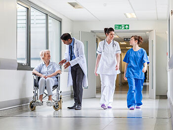 Doctor, nurses and patient in hospital corridor