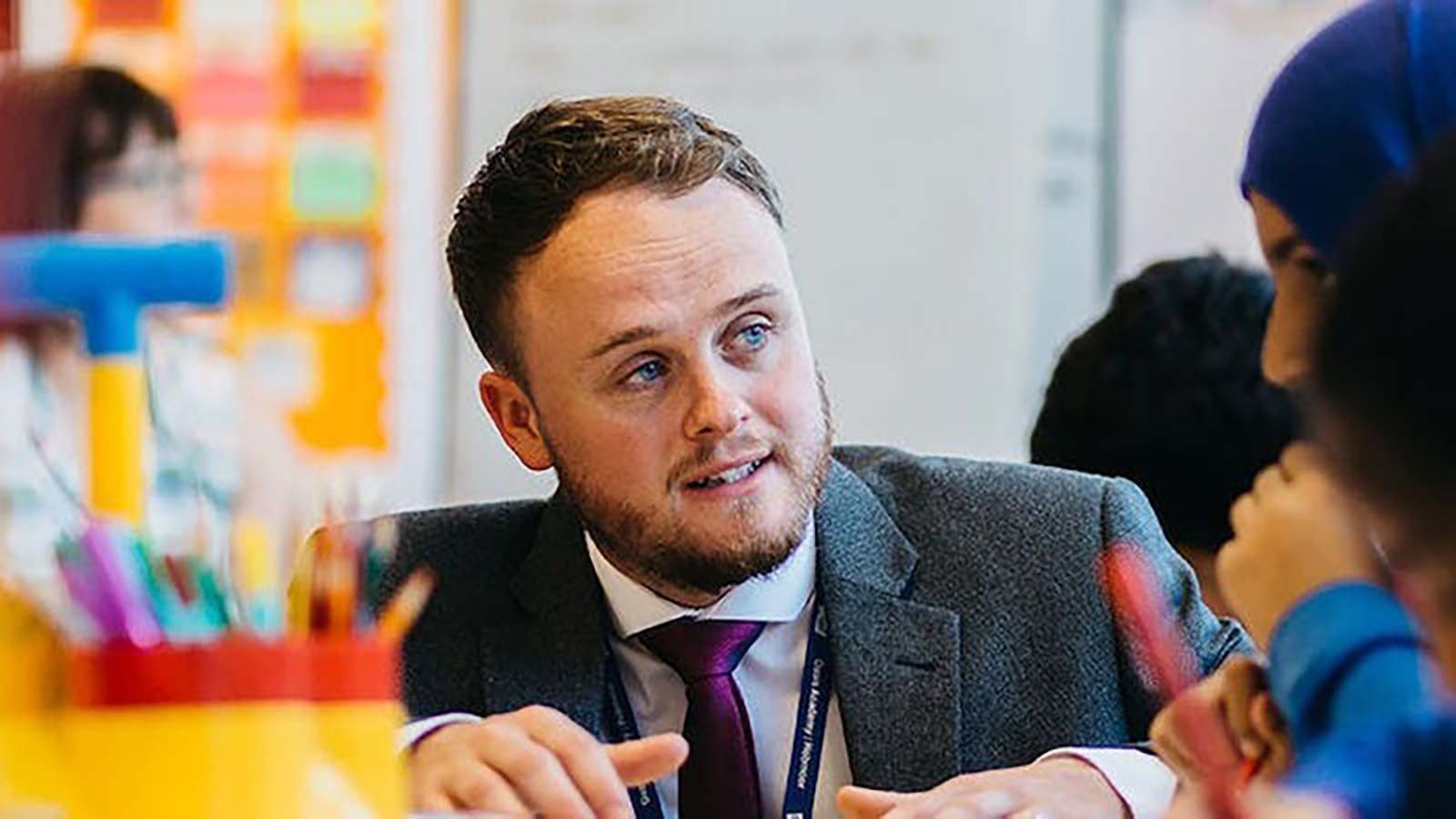 PGCE student talking to school pupils at table