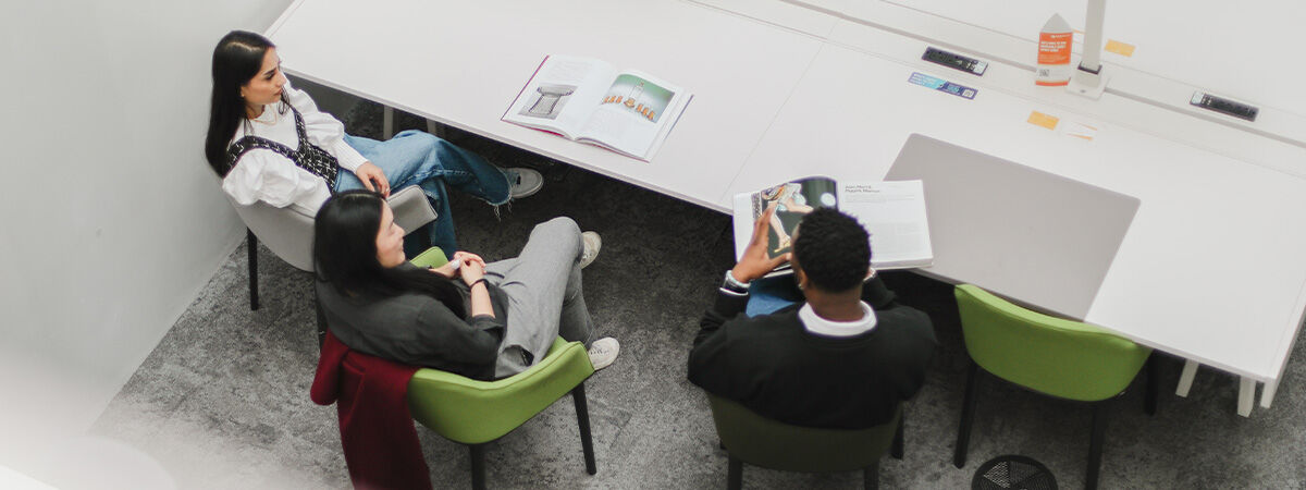 Three PhD Students sat talking in library