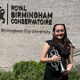Poppy Taylor holding percussion instrument outside Royal Birmingham Conservatoire building