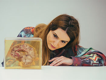 Psychology Course Image 350x263 - Woman looking at a model of a brain