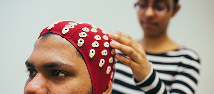 Psychology Labs 682x300 - Woman fitting a man with an EEG scanner