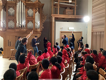 Primary school pupils sat looking at organ