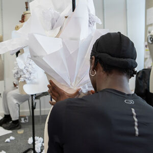 Student styling white garment on mannequin