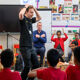 RBC teacher taking part in a music lesson in a circle of children