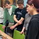 Students gathered round a table looking at work