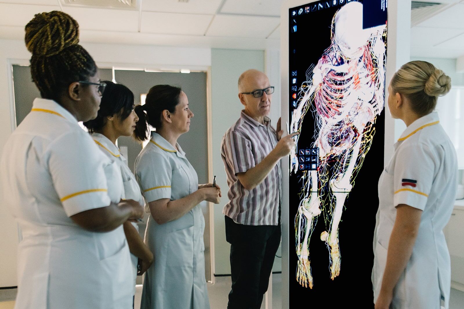 Health lecturer operates state of the art equipment in front of observing students