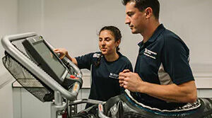 Student monitoring another student on a treadmill