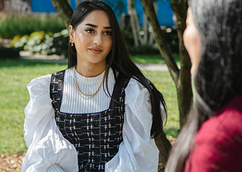 Two students sitting outside talking