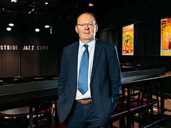 Stephen Maddock stood in Eastside Jazz Club, wearing a suit.