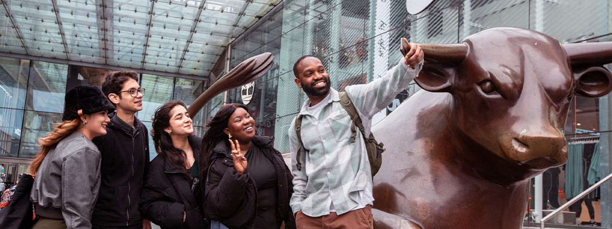 A group of students taking a selfie in front of the Bullring bull 