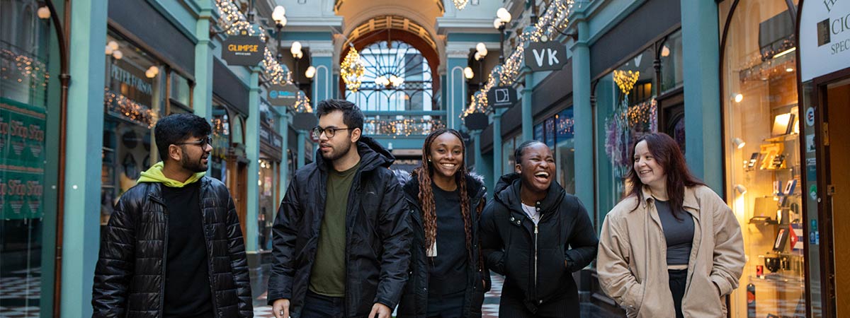 A group of students walk through Great Western Arcade smiling and talking