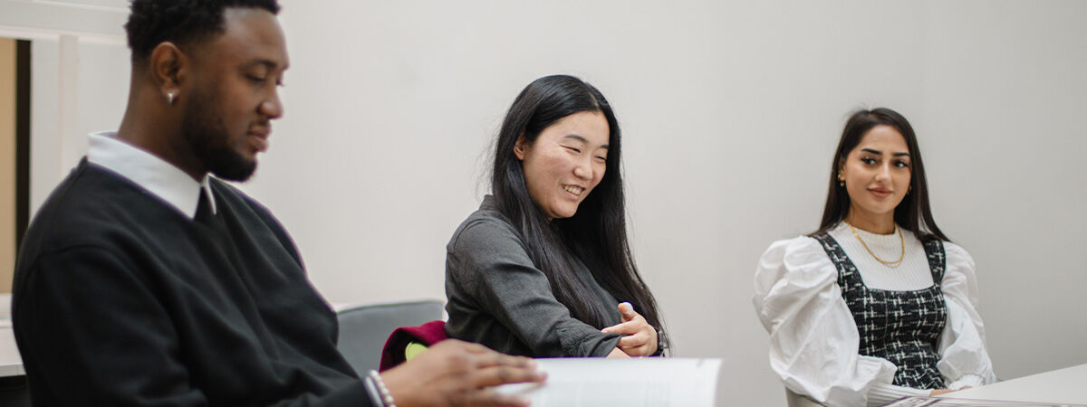 Postgraduate students laughing in a white room