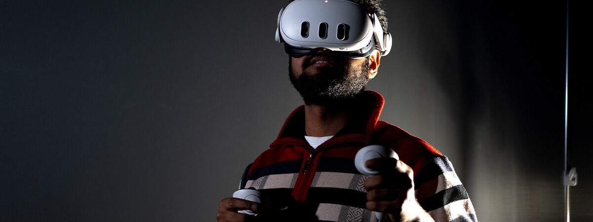 Student silhouetted in darkness using a virtual reality headset