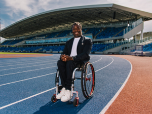 Broadcaster and campaigner Ade Adepitan named new Chancellor of Birmingham City University. Ade is in a wheelchair on the track at Alexander Stadium smiling at the camera