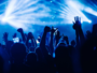 A crowd of people have their hands in the air at a concert