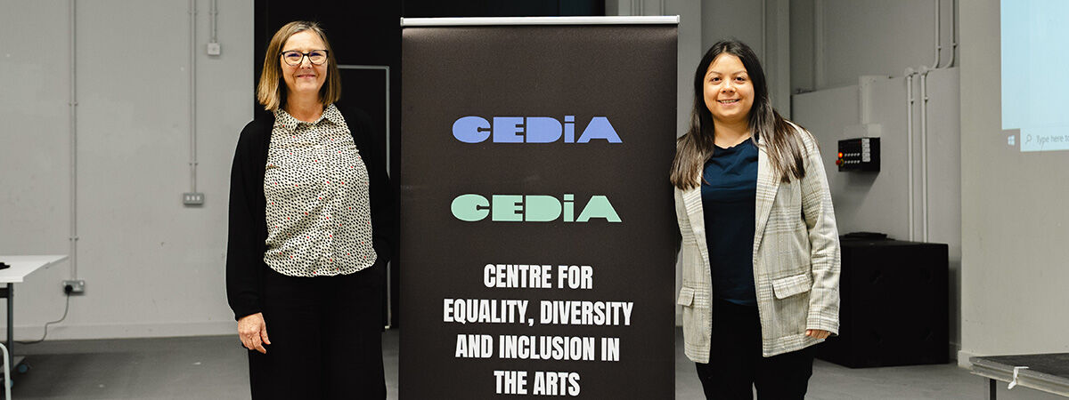 Two academics standing by CEDIA stand